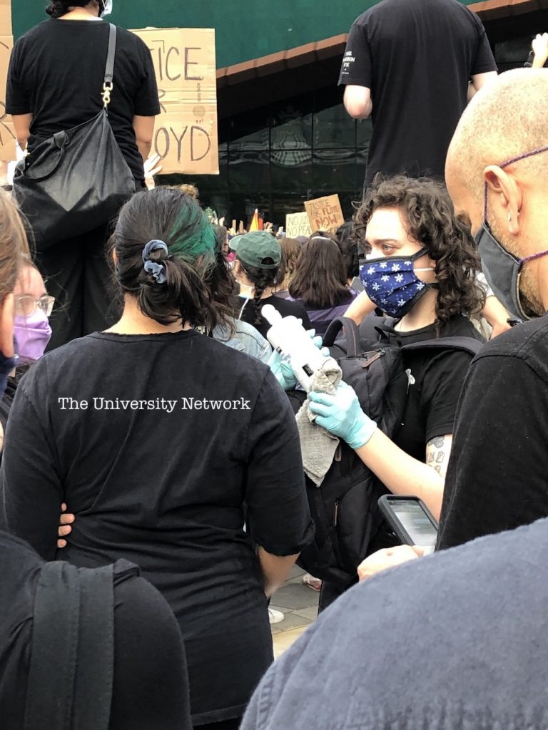 Protester assists fellow protester who was sprayed with pepper spray on Friday